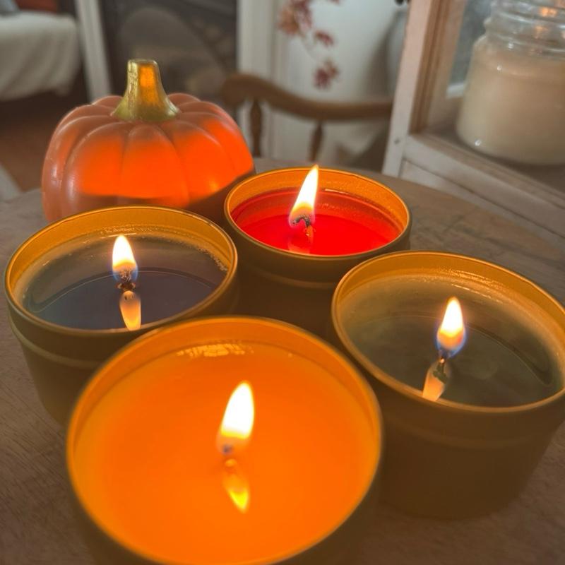 Spellbound Scents candles glowing in gold tins with pumpkin